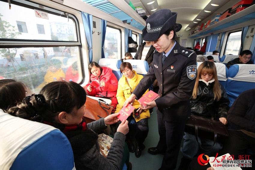 12月4日乘警在车厢内向旅客免费发放《中华人民共和国宪法》。韦士钊 摄